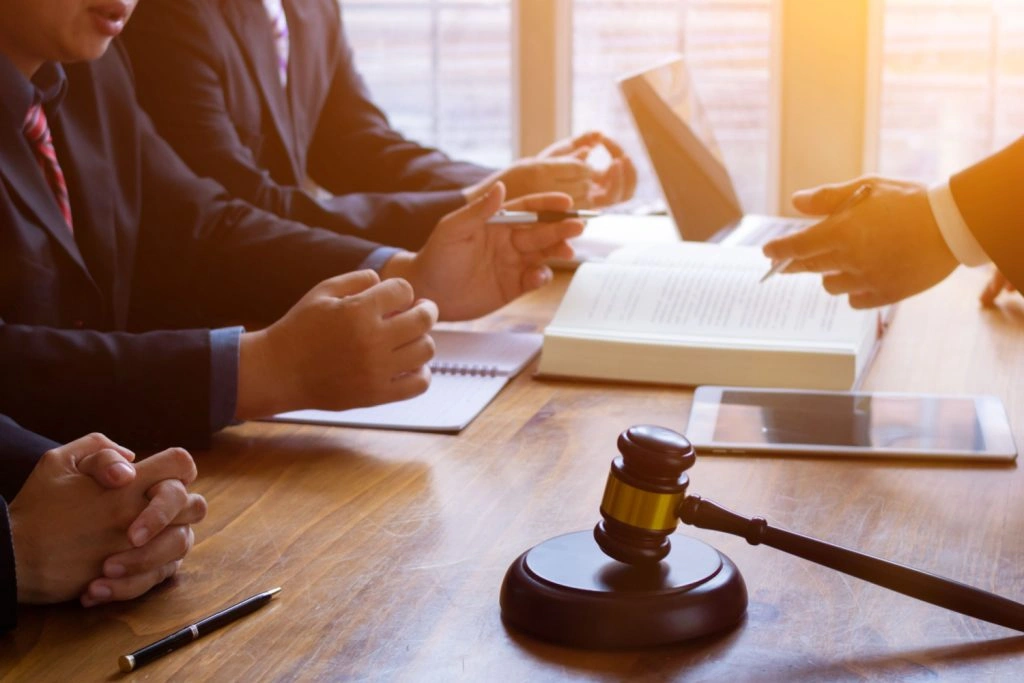 Lawyers discussing a civil litigation case at a table with a gavel and legal documents