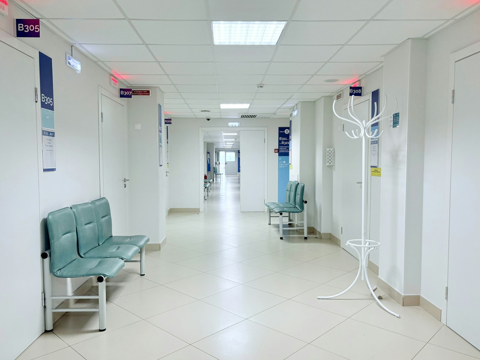 Clean hospital corridor with benches and patient-room doors